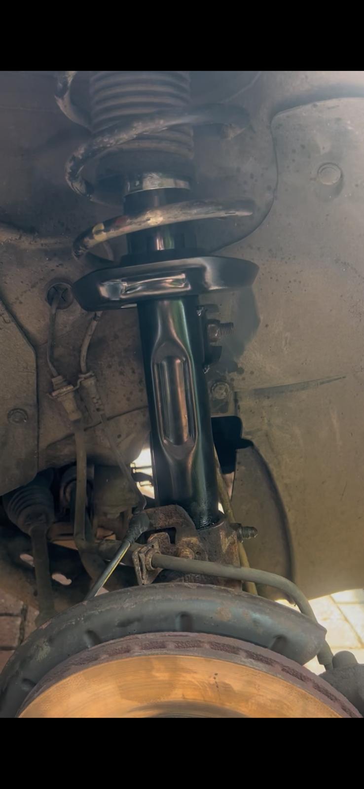 Vehicle suspension and brake assembly being serviced